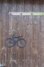 Rustic wooden door with hanging bicycle decoration on brown wood, bicycle, bicycle ornament,