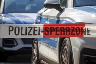 (Photomontage) Symbolic image of a police operation: police cordon in front of emergency vehicles