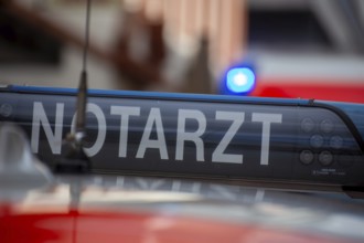 Close-up of an emergency ambulance, flashing blue lights on an ambulance in the background