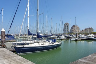 Sailing boats and recreational motorboats moored in marina of fishing village and seaside resort