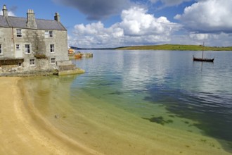 A quiet shore with an old building and a Viking ship in the water, crime series, Shetland Islands,