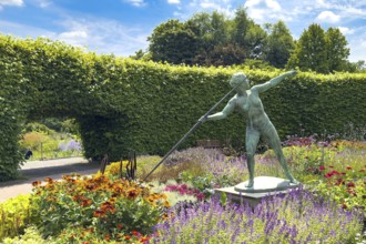 Flower roundabout Lindenrund in Grugapark Essen, in it sculpture statue of bronze javelin thrower