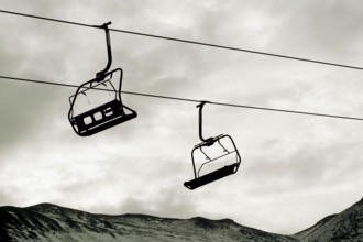 Chairlift ascends over the mountainous landscape in Auvergne, France, highlighting winter