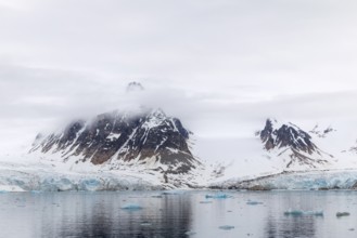 Ice in front of glacier tongue, sea, mountain peak, Smeerenburgbreen, Spitsbergen, Svalbard