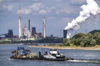 Industrial backdrop of the ThyssenKrupp Steel steelworks in Duisburg-Bruckhausen, cargo ship on the