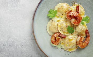 Ravioli with shrimp, in cream sauce, with spices and herbs, top view, no people