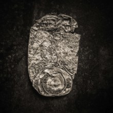 Close-up of a rusty can lying against a dark backdrop highlights the texture and wear of the metal.