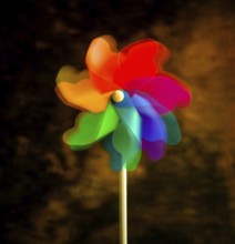 A bright pinwheel spins playfully, showcasing vibrant colors of red, blue, green, and orange. This