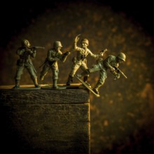 A group of toy soldiers are captured in motion as they navigate a steep incline, showcasing
