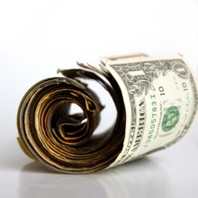 A rolled banknote rests on a clean surface, highlighting the details of the bill and its unique