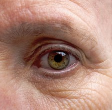 Close-up macro shot revealing the intricate details of an adult woman's eye with vibrant hues and