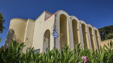 Primary school, Building with arches and Greek flag, surrounded by plants, Armando Bernabiti,