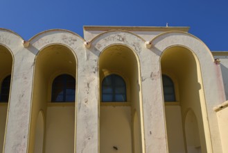 Primary school, Beige-coloured façade with arched windows against a clear sky, Armando Bernabiti,