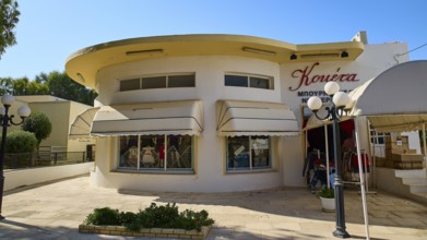 A building with a round façade and large shop windows, sun protection marked, Armando Bernabiti,