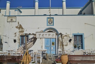 Harbour Authority building, Mediterranean café with white chairs and blue window on a sunny day,