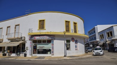 White corner building with shops and parked cars on the street, Armando Bernabiti, Historicism,