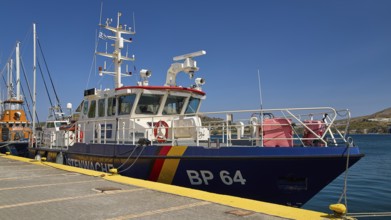 Large patrol boat at the dock in a harbour under a clear blue sky, Frontex. German Coast Guard,