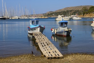 Small boats and sailing boats in a quiet, clear harbour, Lakki, Leros, Dodecanese, Greek Islands,