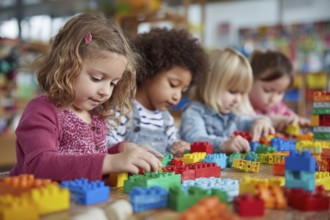 Children developing creativity while playing painting and drawing games at the table at daycare