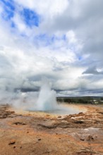 Active Strokkur, tourists watch eruption, high temperature area Haukadalur, tourist attraction at