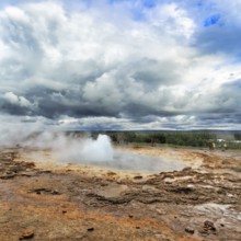 Steaming Strokkur with water column, tourists observe eruption, high temperature area Haukadalur,