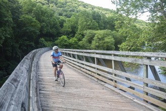 Marlinton, West Virginia - A bicyclist rides across a former railroad bridge over the Greenbrier