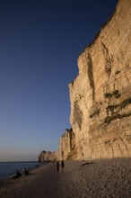 People on the beach, pebble beach, rock arch Falaise or Porte d'Amont, Étretat, sea, steep coast,