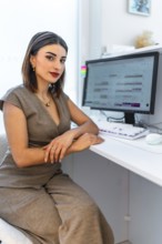 Beautician sitting at desk, using computer software for managing appointments in a modern and