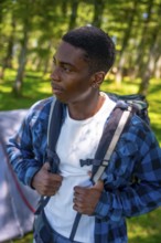 Young hiker adjusting backpack straps, preparing for an exciting journey through the lush forest,