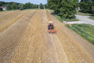 Wayland, Michigan - A farmer uses a rotary tedder to aerate his crop. A tedder spreads out hay or