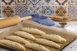 Sprinkle the raw salt sticks with salt and caraway seeds on a baking tray