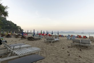 Abandoned deckchairs and parasol after sunset at Charlie Beach, Koh Mook Island, Andaman Sea,