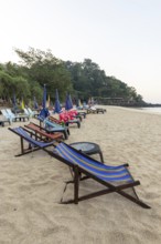 Abandoned deckchairs and parasol after sunset at Charlie Beach, Koh Mook Island, Andaman Sea,