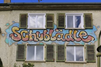 Clothes shop and meeting café Schublädle, mural, house facade, writing, social project, second-hand