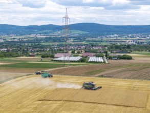 Harvesters and tractors in a field under a blue sky in a mountainous landscape, Korb im Rems