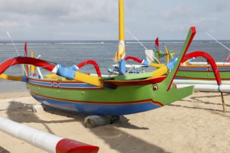 Colourfully painted fishing outriggers on Sanur beach, Bali, Indonesia