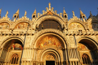 Warm glow of the setting sun on the detailed architecture of the Basilica San Marco in Venice,