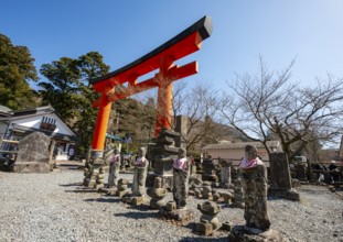 Stone statues and red torii gate, Sai no Kawahara, first torii of Hakone Shrine, Motohakone,