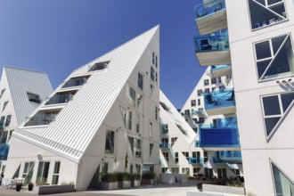 Distinctive white residential complex, turquoise balconies against blue sky, pyramid-shaped