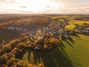Aerial view of a village surrounded by autumn trees and fields at sunset, Lehenweiler, Aidlingen,