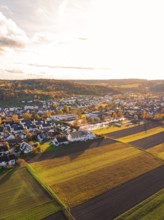 Aerial view of a village surrounded by fields in warm autumn colors, Aidlingen, Böblingen district,