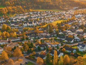 View of village in autumn light with colorful trees and houses, bathed in warm sunlight, Aidlingen,