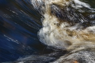 Stream flow with dark water, reflections and turbulences, long exposure, Sweden
