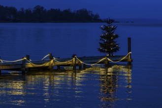 Illuminated Christmas tree at dawn, on an illuminated boat dock, Dießen am Lake Ammer, Upper