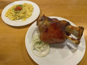 Crispy fried pork knuckle with crust, potato salad, onions, on table, food, Stuttgart,