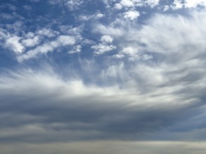 White clouds above Altocumulus floccus below Altostratus in front of above blue sky, international