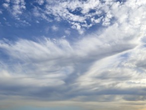 Above white medium-height clouds Altocumulus floccus below Altostratus in front of above blue sky,