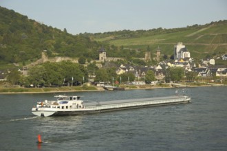 Cityscape with city fortifications and towers of Oberwesel on the Rhine with cargo ship,