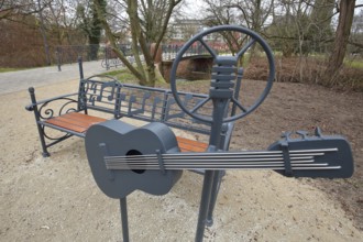 Memorial and sculpture to Elvis Presley with guitar park bench, music notes, microphone, USA