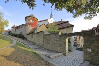 Historic city wall with wall tower, city fortification, archway, autumn colors, stairs, bridge